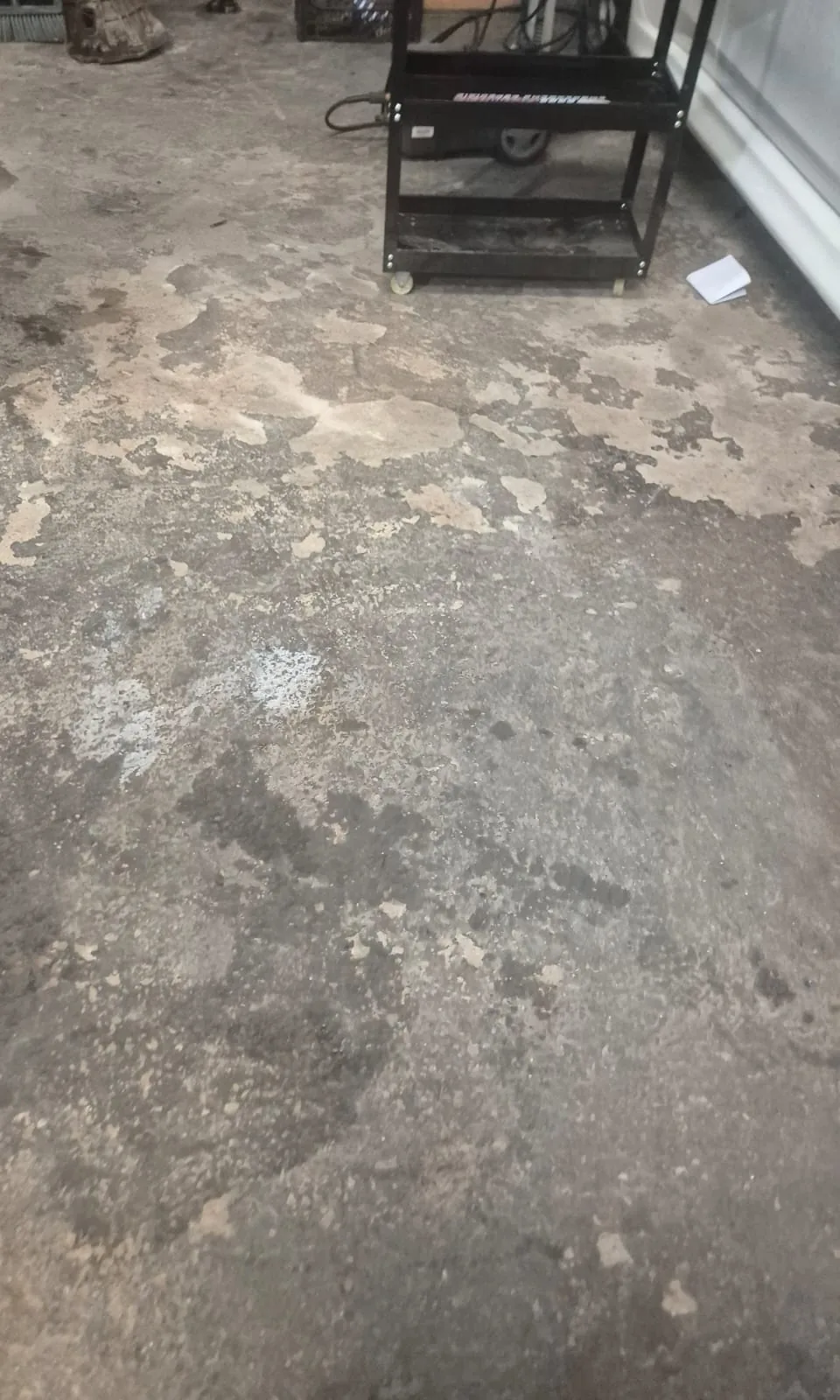 Piso de concreto sujo e manchado em oficina, no estado em que chegou