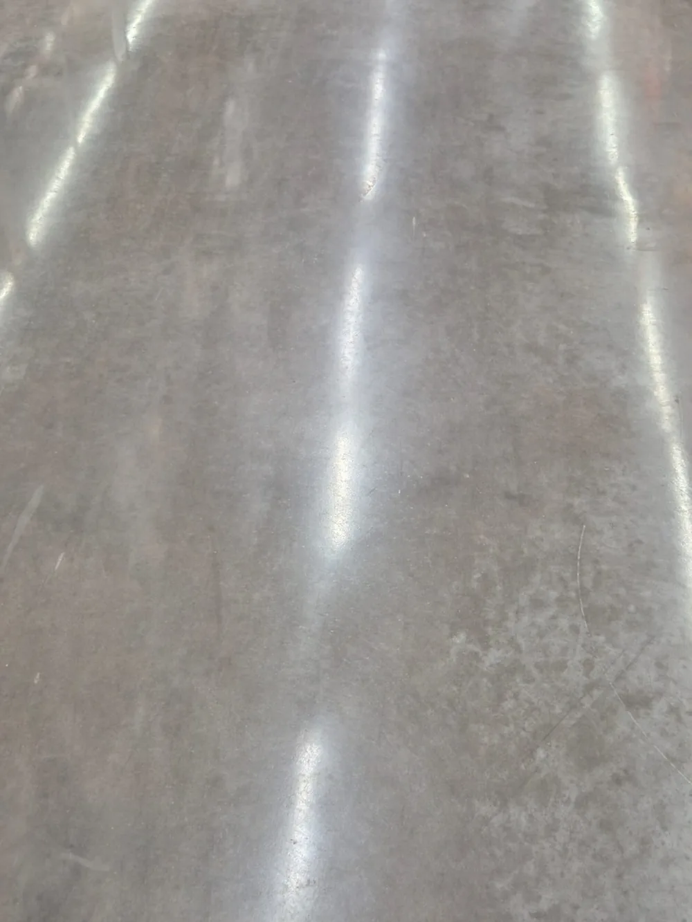 Piso de concreto polido com reflexo forte de luminária, depois do acabamento