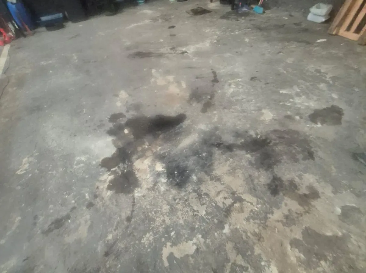 Piso de concreto desgastado e manchado de óleo em garagem, mostrando o problema a corrigir