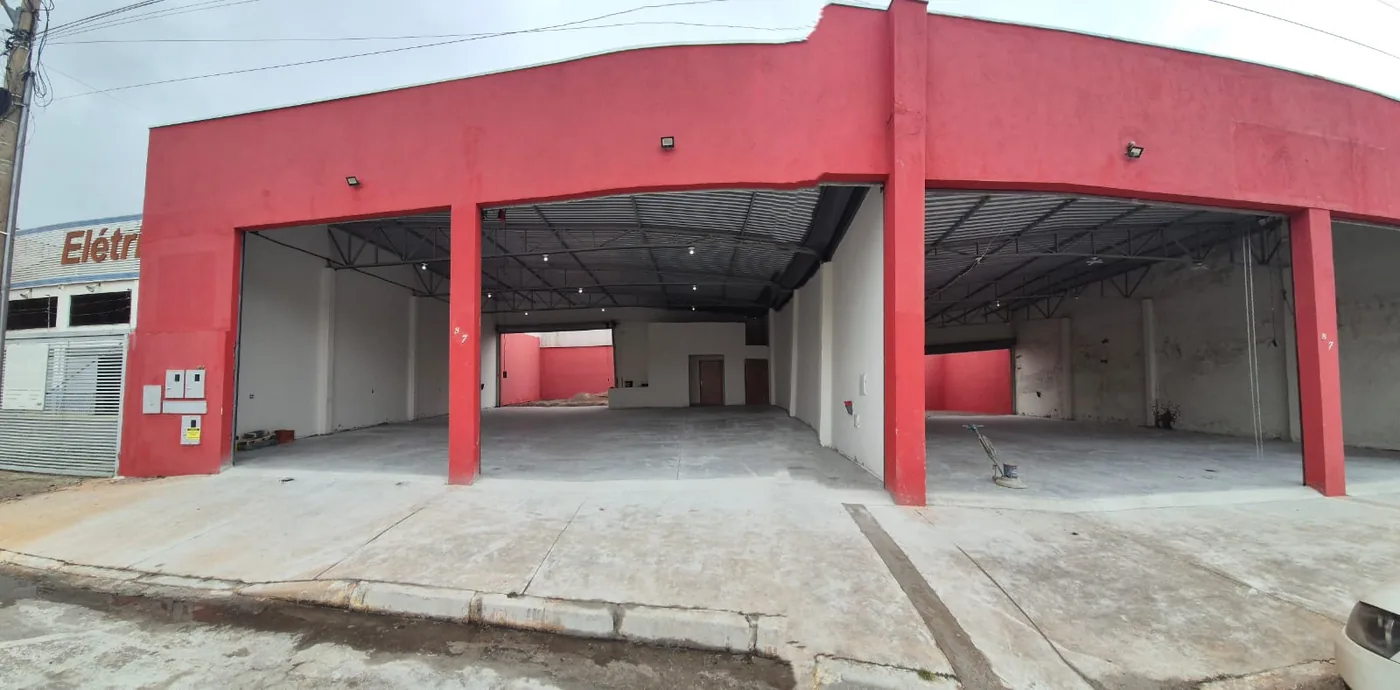 Fachada vermelha de loja comercial com piso de concreto executado