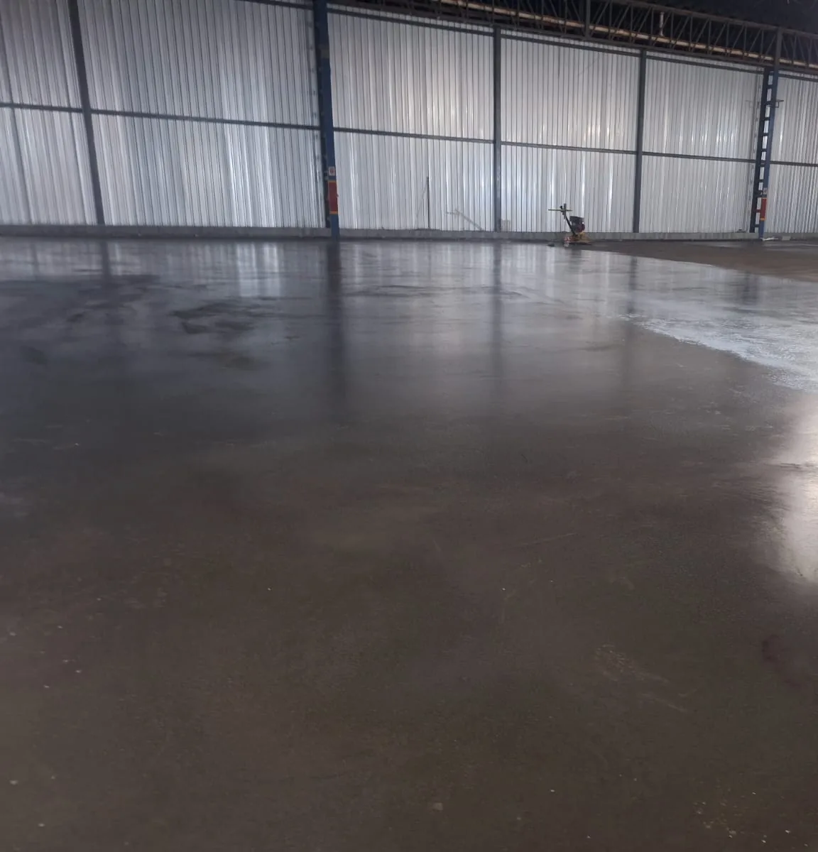 Piso de concreto pronto, liso e espelhado, em galpão vazio recém-entregue